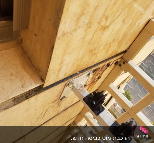 ברגים ומסגרת מתכת מחוברת לקיר אבן